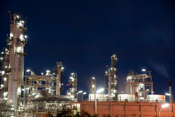 Oil refinery plant chemical factory and power plant with many storage tanks and pipelines at sunset