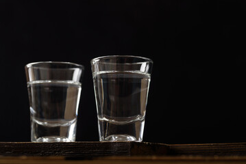 Vodka in a shot glass on black background
