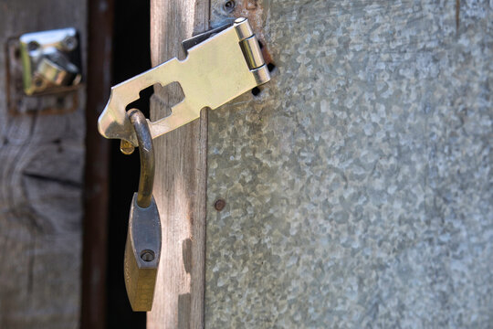 An Unlocked Padlock Hanging From An Open Shed Door