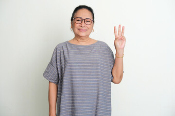 Elderly Asian women smiling to the camera while give three fingers sign