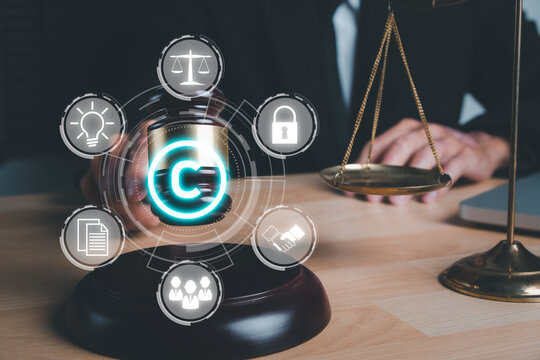 Copyright or patent concept, Woman hand holding judge gavel on desk with VR screen copyright icon background, Copyleft trademark license, Creation ownership against piracy crime.