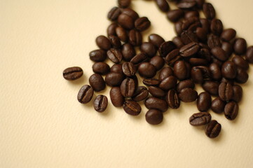 マイルドで香り高いコーヒー豆が生成りの背景に。カフェで珈琲で一服。	