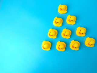 A group of toys duck in the shape of an arrow. Social organizations, commercial structure. Organization, joining consolidated forces. Team building, teamwork cooperation. Discipline in hierarchy.