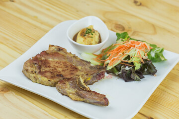 Grilled steak pork chop with boiled potatoes and vegetable salad
