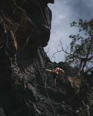 Rock clibing in a sunny day from below