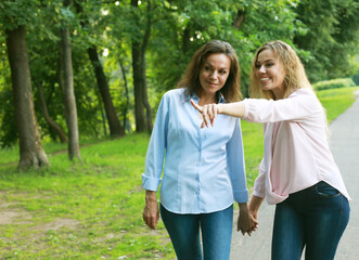 Two beautiful women - mother and daughter, spend the weekend in the park.