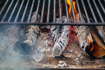 Burning firewood with flame through bbq grill grates. High-quality photo