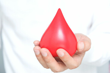 healthy man's hand holding blood symbol Blood Donation Help and Health Concepts