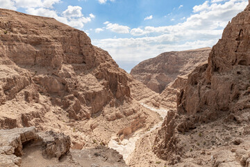 Fototapeta na wymiar Dry river bed passing through the stone desert near the Khatsatson stream, on the Israeli side of the Dead Sea, near Jerusalem in Israel