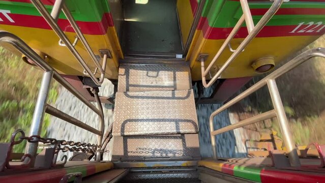 Train riding to Maeklong Station, local umbrella market (Talad Rom Hub). Top view train bogie walking steps connector moving high speed background - day
