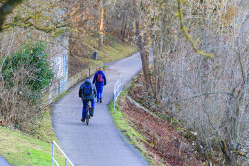 Obraz premium Regensburg, Germany: people are riding the bike on a rural road at sunset along Danube river in Regensburg, Germany, Europe.