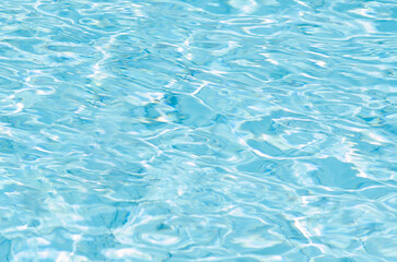 Blurred background of blue color water of swimming pool at day time.