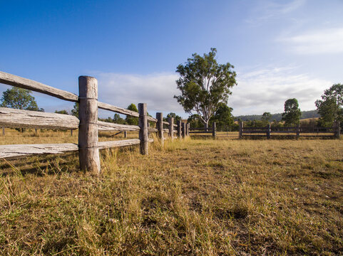 Low down view of wooden post and rail fence.
