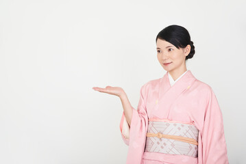 手で案内する着物を着た女性