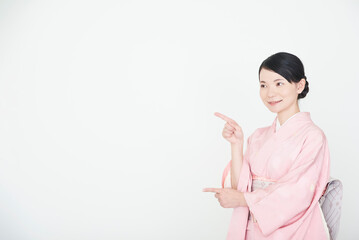 指で指し示す着物を着た女性