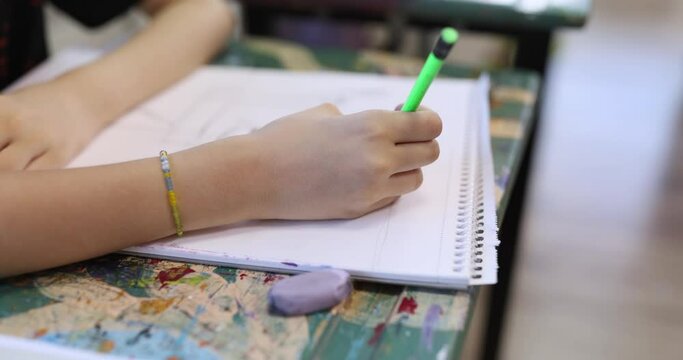 child draws sketch of drawing with pencil on paper