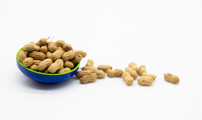 dry Unpeeled peanuts in a cup close up isolated on white background