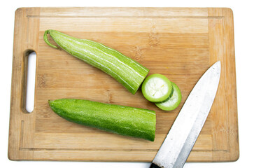 fresh Snake gourd slices over wooden background.