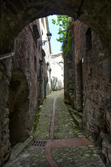 A narrow street between the old houses of Petina, a village in the mountains of Salerno province,...