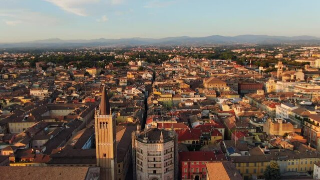 parma aerial view drone wide shot of city historic center,cathedral baptistery and duomo square,flying backwards at dawn no people