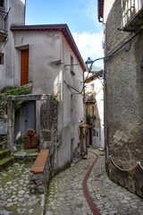 A narrow street between the old houses of Petina, a village in the mountains of Salerno province,...