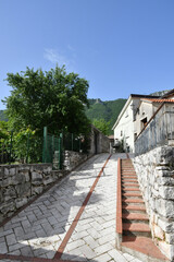 A narrow street between the old houses of Petina, a village in the mountains of Salerno province,...