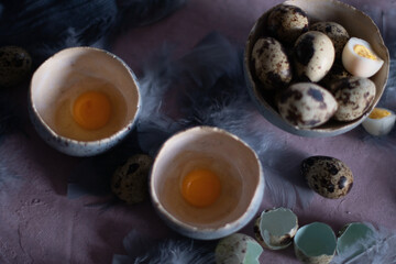 quail eggs in ceramic vases, gray feathers on the table, easter still life,
