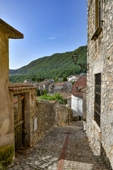 A narrow street between the old houses of Petina, a village in the mountains of Salerno province,...
