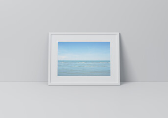 Tropical sea and blue sky poster in horizontal white frame on floor over grey wall, 3D rendering