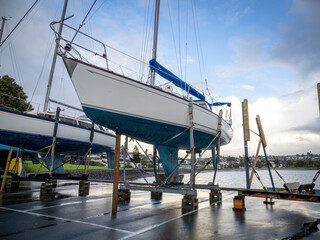 Small yacht on dry dock stand being repaired