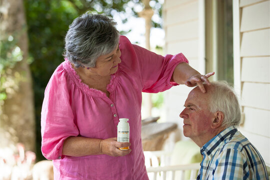 Wife taking care of her husband applying sunscreen