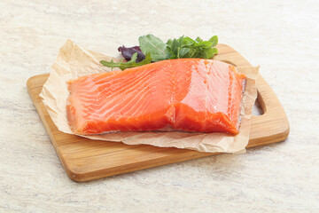 Raw salmon fillet over board