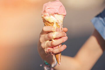 Cute girl eating ice cream on summer background outdoors. closeup portrait of adorable redhaired little girl eating ice cream.