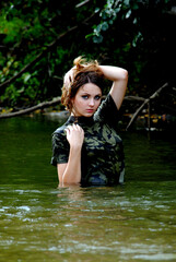 Fototapeta premium Ukrainian military girl with a paddle on the river near the kayak
