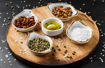 Oil, herbs and spices on wooden background