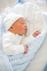 Newborn baby laying in crib in prenatal hospital