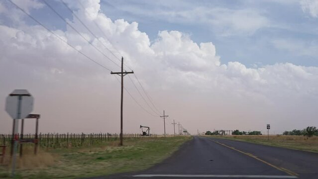 Driving through West Texas looking out the window at dust storm blowing in moving in slow motion.