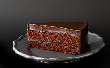 Sliced of Chocolate cake, sweet and delicious cake, closed up shot on black background, dark mood photography style.