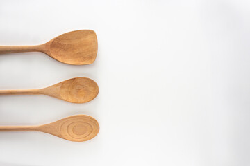 Wooden kitchen tools, spoon  and spatula, top view shot on white background.