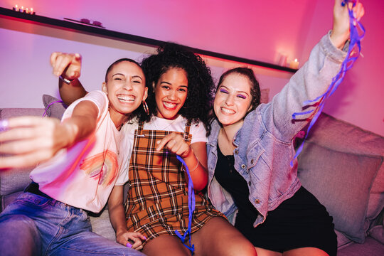 Three girlfriends having a good time at a house party