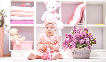 baby with lilac flowers at home or kindergarten