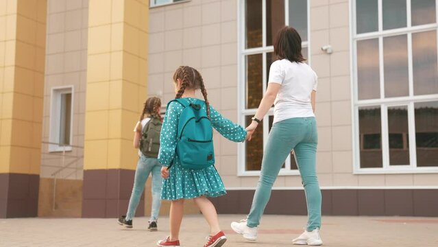 back to school. mom and daughter a go hand in hand to school for lesson. education support training concept. child lifestyle walk to school with a backpack. daughter mom rush to school. family day