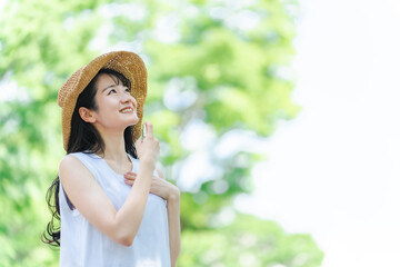 日焼け止め・虫除けスプレーする女性（笑顔・首）
