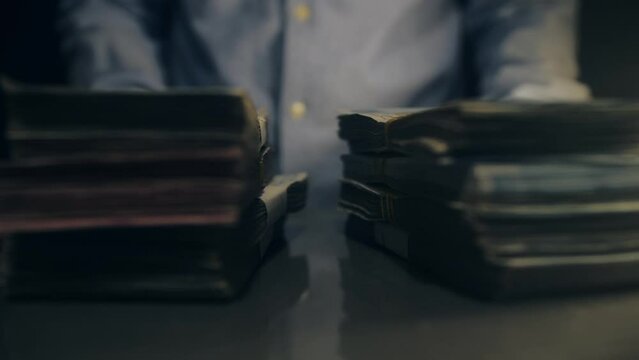 Male hands hold bundles of dollars bills in the strap. Success man with pile of money.