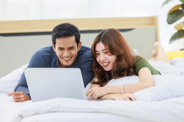 Asian happy romantic male female husband and wife lover couple lay down smiling together on pillow...