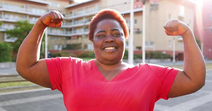 Strong woman flexing muscles in the street
