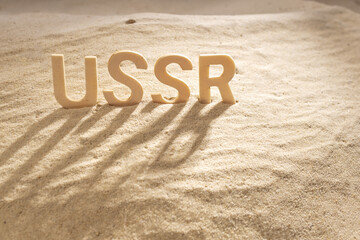 wooden letters on the sand, the past name of Russia is written Ussr