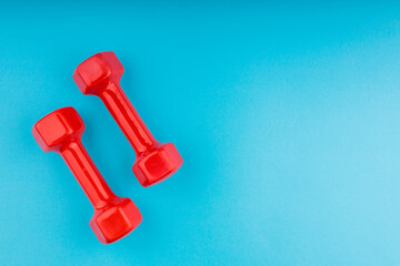 two red dumbbells on a blue gradient background