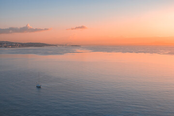 Areal view of seascape view and small ship sailing in sea at sunrise sky 