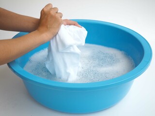 Woman hands washing white clothes in sink. closeup photo, blurred.